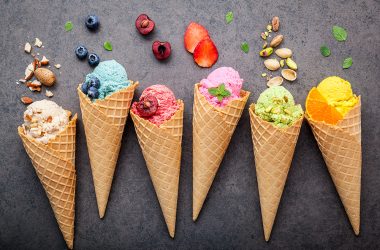 Various of ice cream flavor in cones setup on dark stone background .
